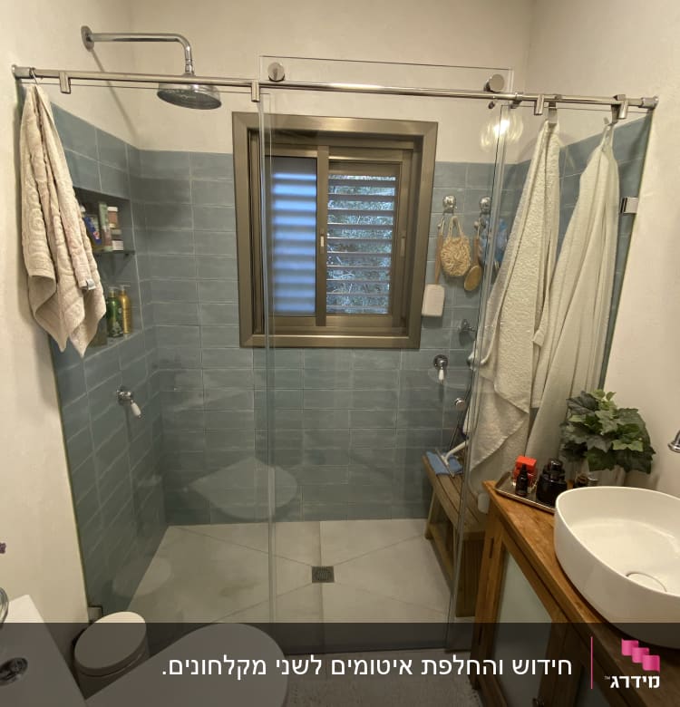 מקלחת עם ראש מקלחת, מגבות ומוצרי טיפוח